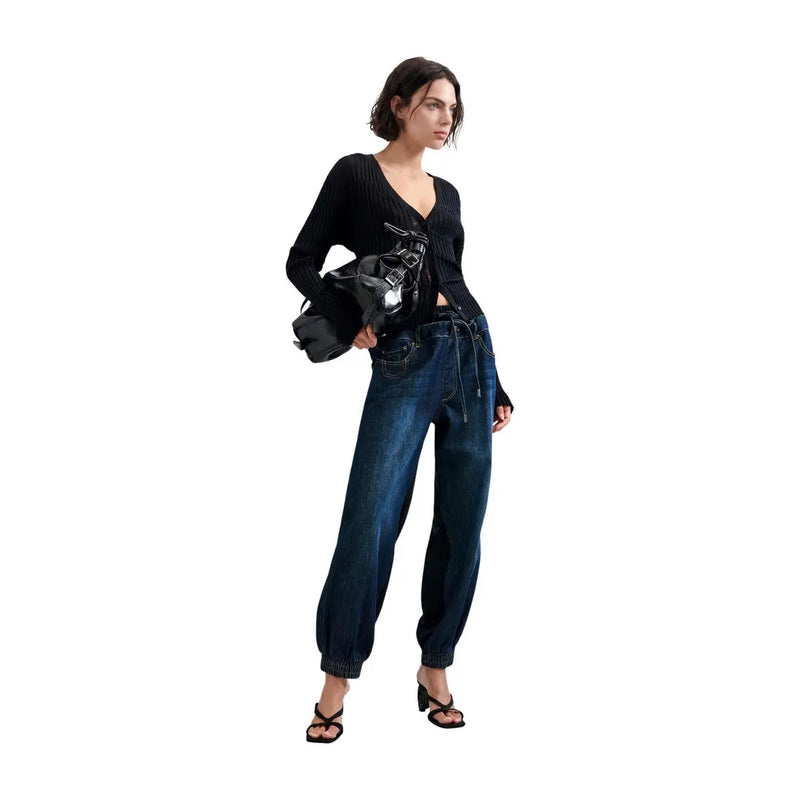 Gilet noir en maille texturée à col en V et manches longues, porté avec un jean bleu en denim de coton mélangé Desigual pour femme