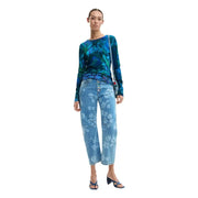 Pull Desigual pour femme, bleu à fleurs, manches longues et col rond, associé à un jean en denim bleu à fleurs blanches.