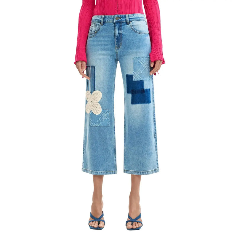 Jean Desigual pour femme en denim de coton bleu clair délavé, coupe courte, orné de patchwork brodé bleu et crème.