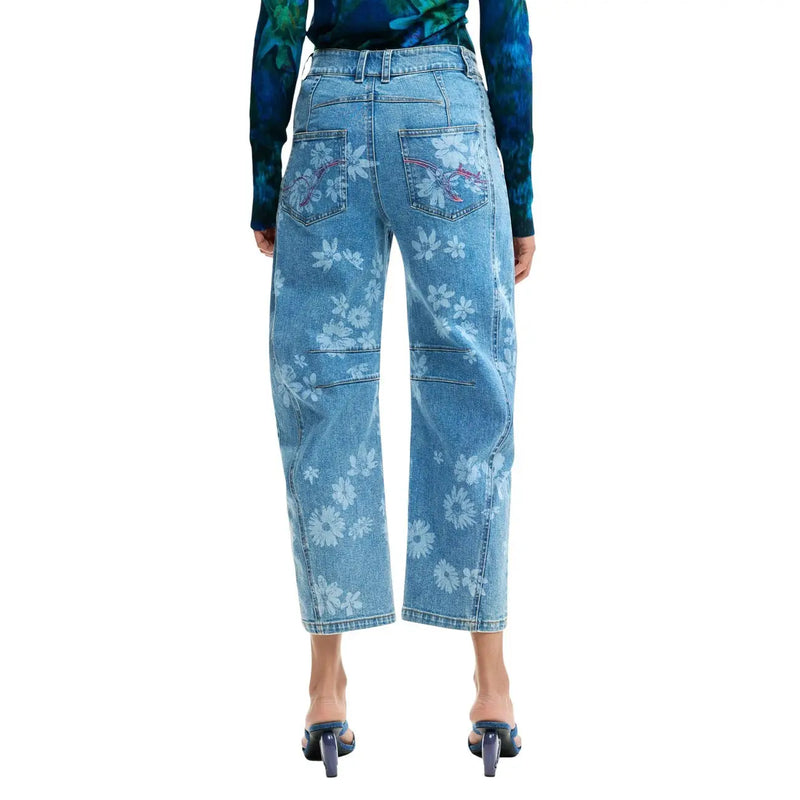 Jean en denim clair délavé avec broderies florales blanches et roses sur jambes larges et courtes, poches en coton, de la marque Desigual