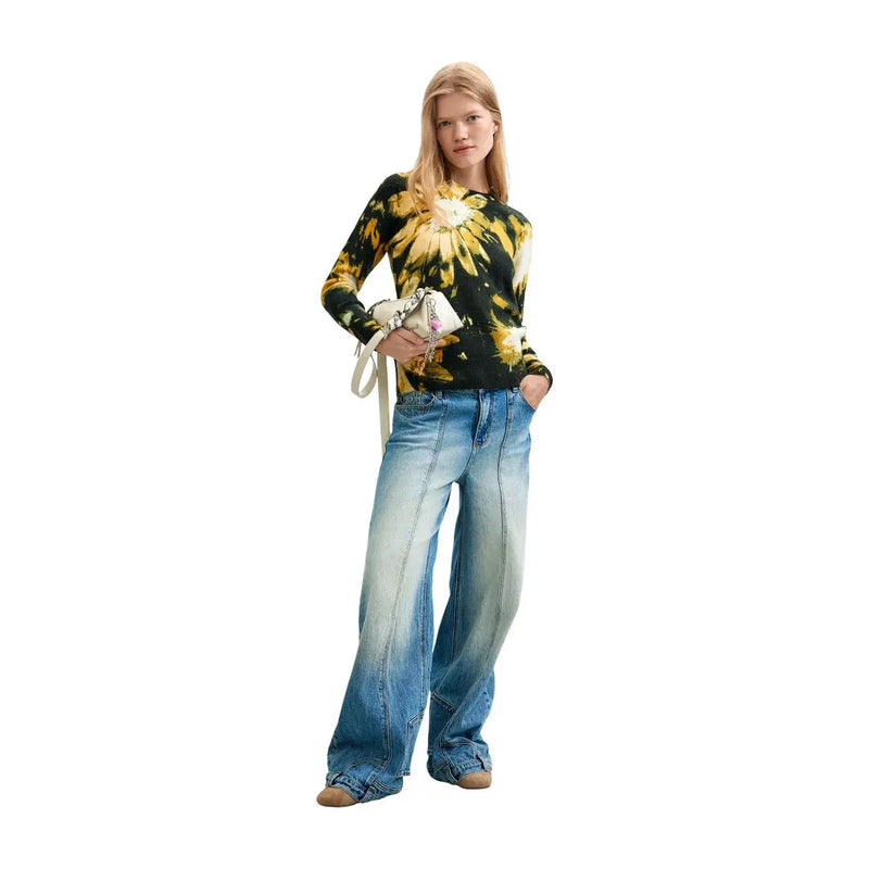 Une femme porte un pull Desigual pour femme en maille florale noire, mélange acrylique, à motif tie-dye floral noir et jaune.