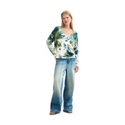 A woman wears a desigual women floral knitwear white viscose blouse with long sleeves and an abstract floral pattern
