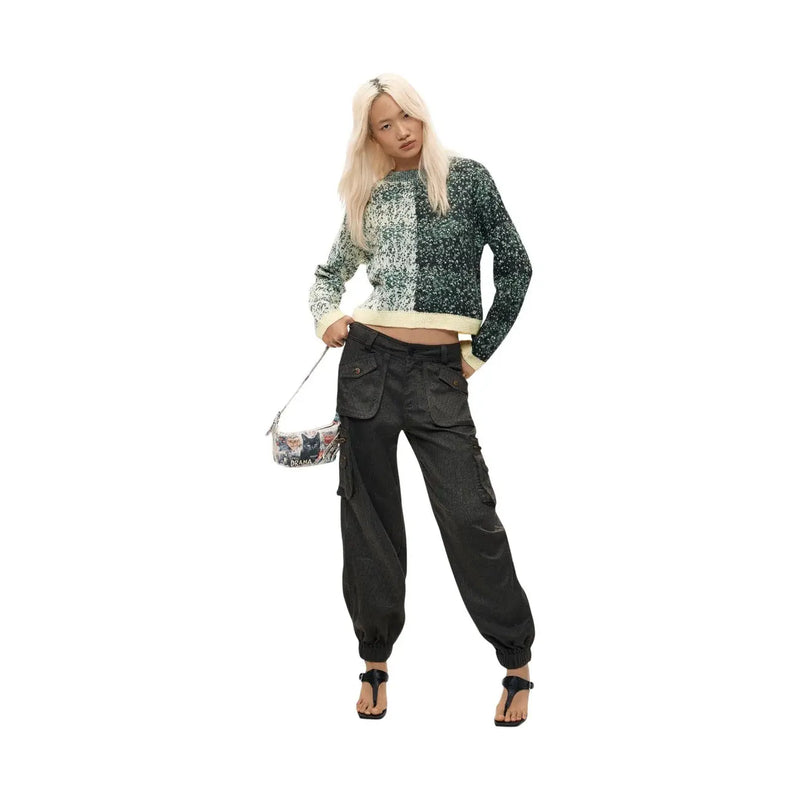 Pantalon cargo noir à ourlets élastiques et poches multiples, porté avec un pull en maille verte en laine mélangée Desigual pour femme.