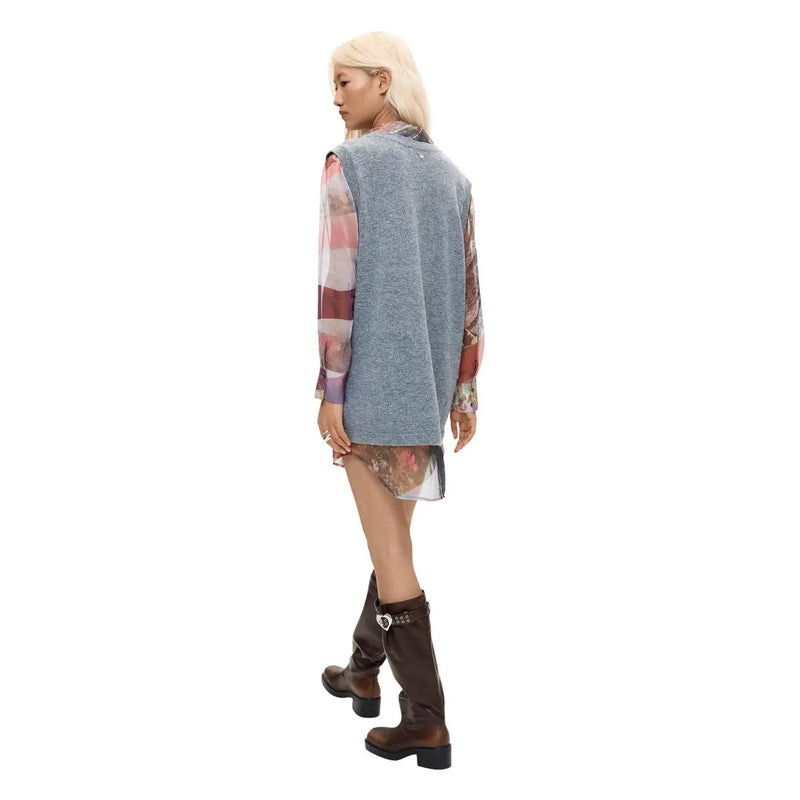 A woman wearing a desigual women grey polyester sleeveless low cut dress with floral pattern and gray knit vest