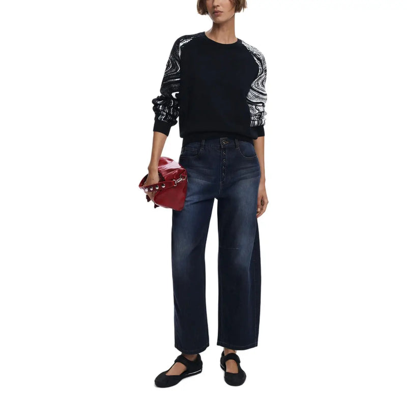 Pochette en cuir rouge brillant ornée de clous argentés et d'une bandoulière chaîne, présentée avec un pull en maille Desigual pour femme.
