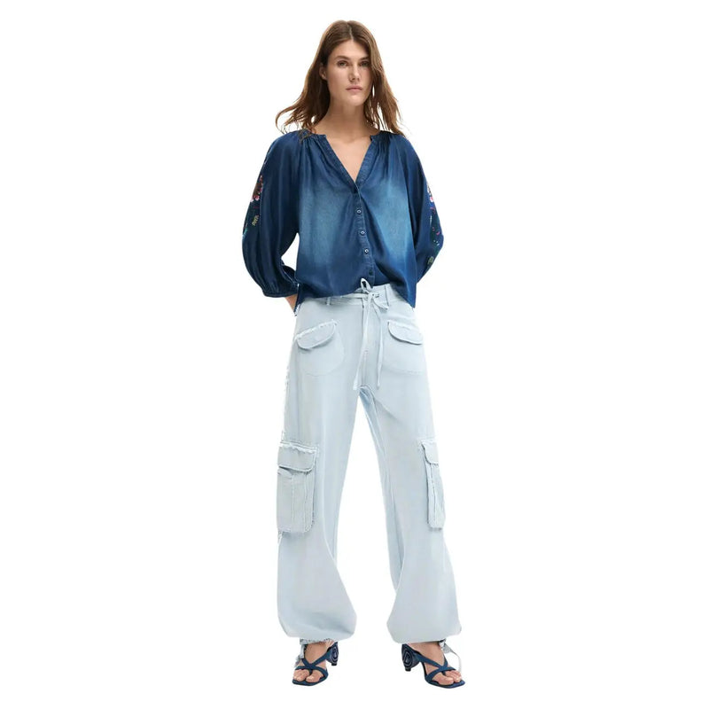 Chemisier en denim bleu à manches brodées et fermeture boutonnée sur le devant, associé à un pantalon en coton bleu clair à lacets Desigual pour femme.
