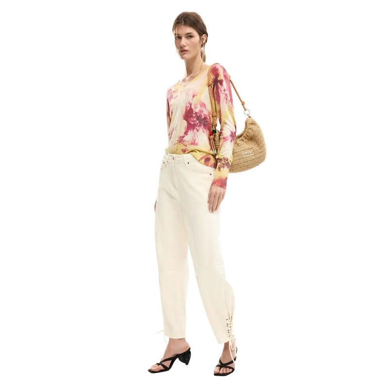 Sac bandoulière en paille tressée à la texture naturelle et à la bandoulière dorée, associé à un pantalon en coton beige Desigual