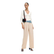 Pantalon Desigual pour femme, beige, zippé et boutonné, en viscose mélangée, avec un sac bandoulière noir orné d'un empiècement en cuir rouge et d'une bandoulière en denim.