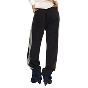 Pantalon de survêtement Desigual pour femme, noir, en mélange de coton, coupe slim, avec bandes réfléchissantes argentées et ourlets à revers.