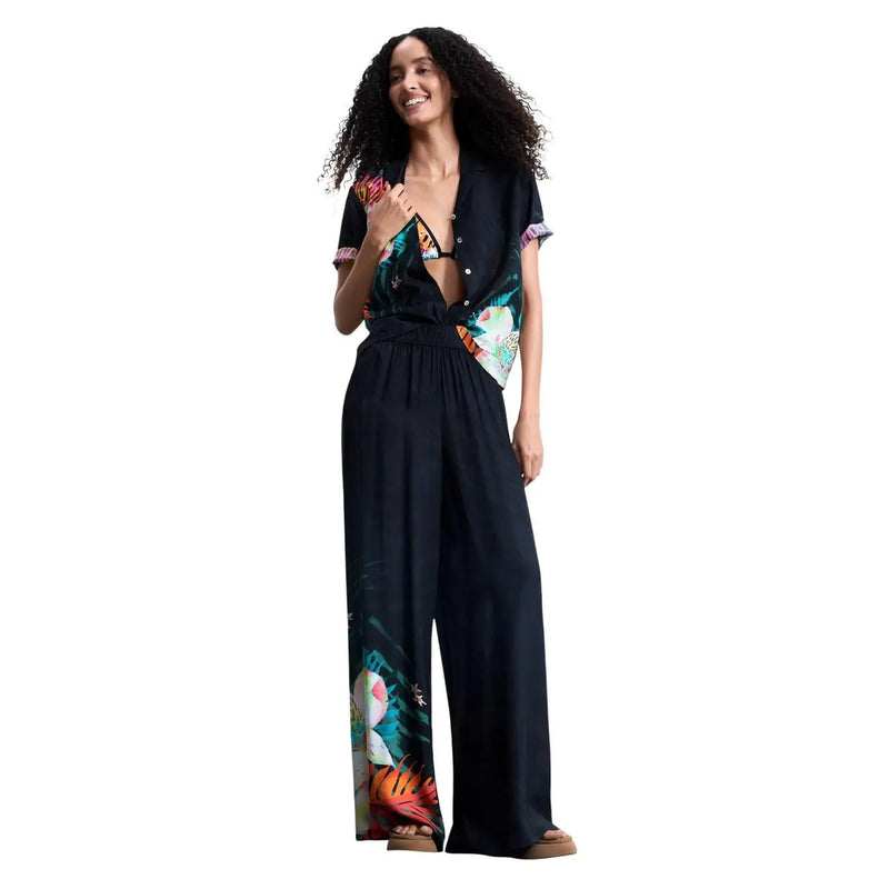 Combinaison noire à imprimé tropical signée Desigual pour femme, ornée de motifs floraux et d'oiseaux éclatants sur un tissu en viscose léger.