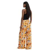 Pantalon Desigual pour femme, en viscose orange à fleurs avec imprimé floral jaune, coupe large, tissu léger et taille élastiquée.