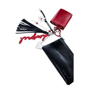 Porte-clés en cuir rouge et noir avec breloques étoiles, pompons et pendentif cœur argenté, attaché à un portefeuille Desigual pour femme en polyuréthane noir zippé