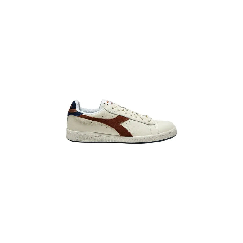 Diadora Baskets basses pour homme en daim beige, avec empiècements en cuir crème, large bande diagonale marron et détails bleu marine au talon.