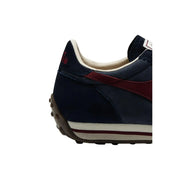 Diadora Baskets pour hommes en cuir bleu marine et bordeaux avec des bandes blanches sur la semelle intermédiaire, inspirées des chaussures de rallye cirées.