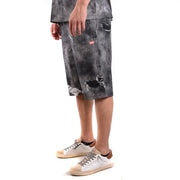 Diesel Short en coton pour homme, gris foncé, genoux déchirés et usés, logo rouge sur la poche avant (vue de face).
