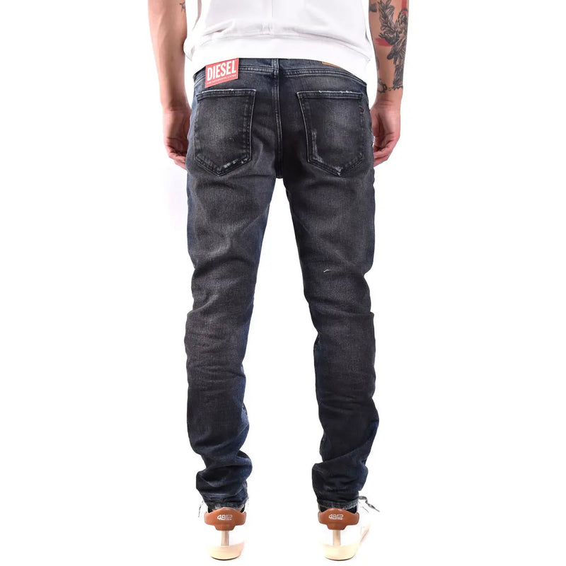 Diesel Jean homme en denim brut délavé, effet usé, avec étiquette de marque à l'arrière de la ceinture (vue de dos)
