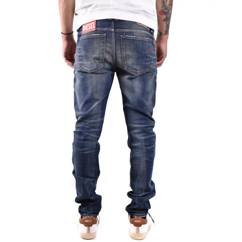 Jean en denim bleu foncé délavé et usé, avec logo Diesel à l'arrière de la ceinture.
