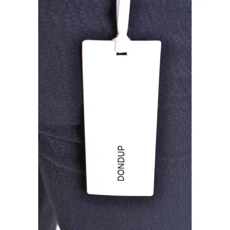 White rectangular dondup brand tag attached to dark navy cotton fabric of men’s spring summer blue trousers