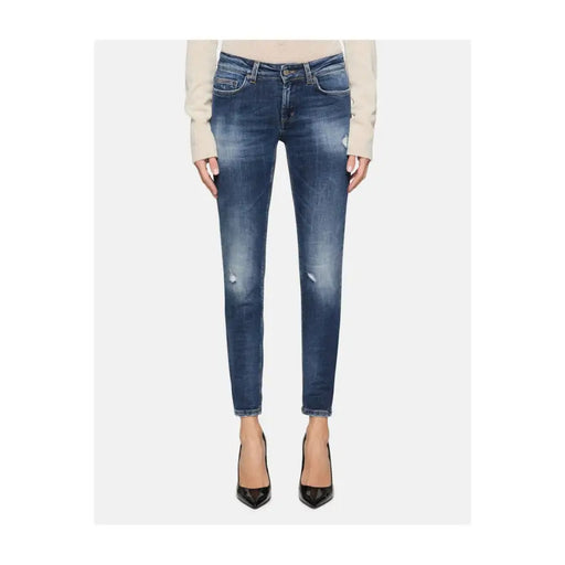 Distressed blue skinny jeans with ripped effect, paired with a light top and black heels