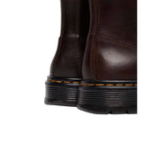 Bottines chukka Brookline pour homme Dr Martens, en cuir marron avec tige en cuir marron foncé, semelles en caoutchouc noir et surpiqûres jaunes.