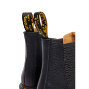 Bottines Dr Martens pour homme en cuir noir avec tige en cuir texturé, doublure beige et logo jaune sur les languettes.