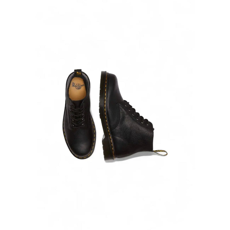 Bottes Dr. Martens homme en cuir noir à lacets, montrant l'arrière avec semelle robuste et boucle au talon.