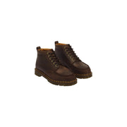 Bottes chukka Dr. Martens pour homme en cuir marron foncé, gros plan sur la texture du cuir.
