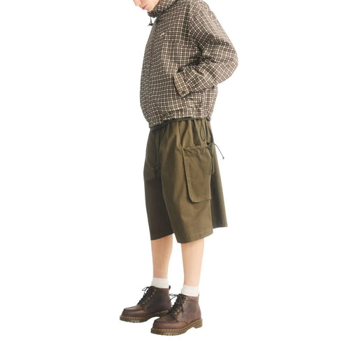 Short cargo vert olive à taille élastiquée et poches, présenté avec des bottines chukka en cuir marron Dr. Martens pour homme.