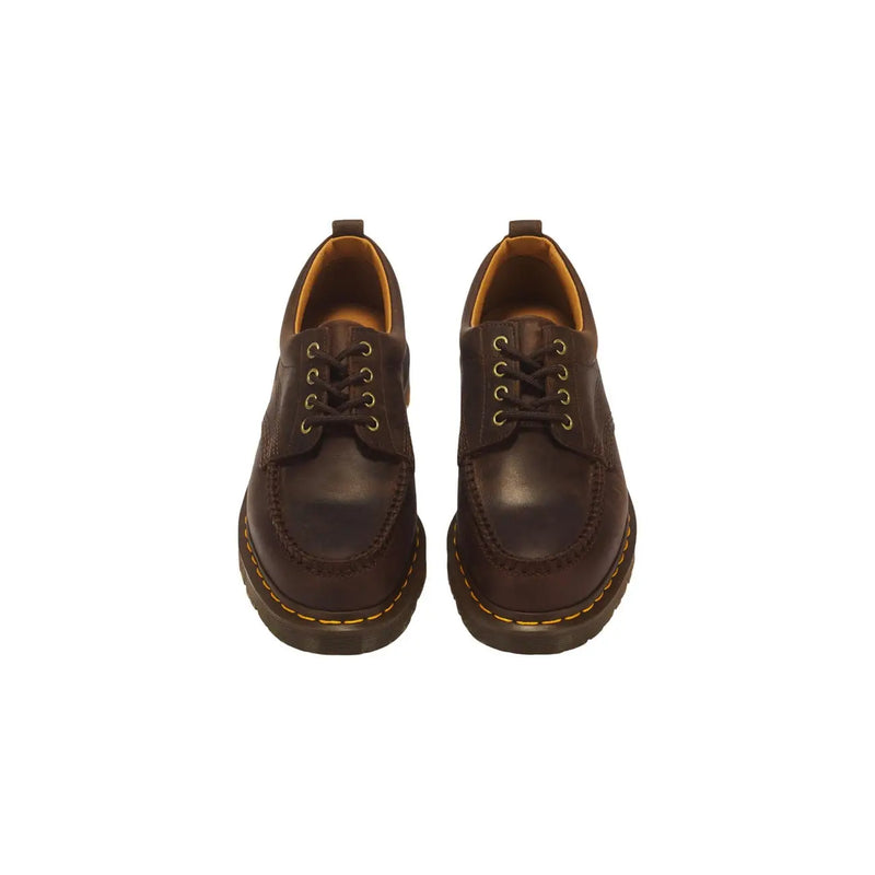 Bottes Dr. Martens pour homme, en cuir marron foncé, à enfiler, avec une finition lisse et un design discret.