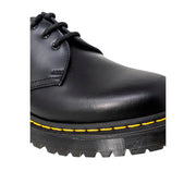Dr martens men’s black leather lace-up shoes showing the back side with sturdy heel and classic design