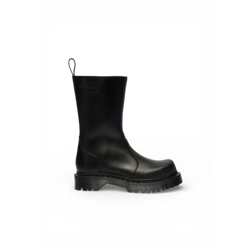 Vue arrière de la bottine Dr. Martens pour femme en cuir noir, à semelle épaisse en caoutchouc et languette de tirage.