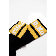 Sous-vêtements Dr Martens pour femme, en coton stretch noir mélangé, portés avec des chaussettes rayées noires et jaunes ornées du logo Dr Martens blanc.