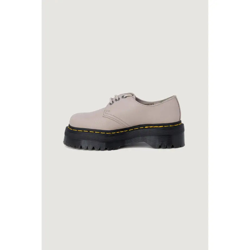 A beige leather slip-on Dr Martens shoe for women shown from the back side highlighting its material and design