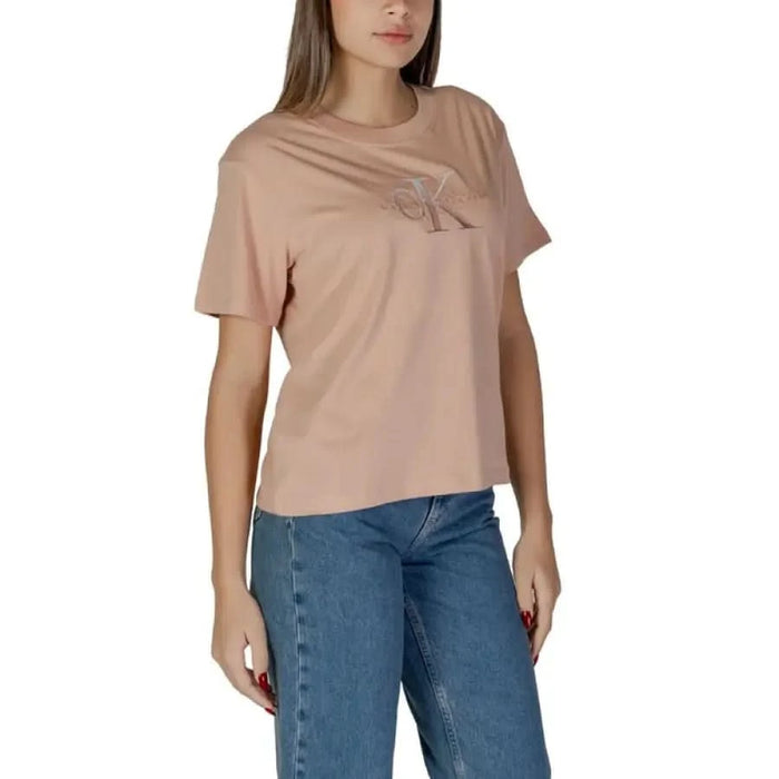 Dusty pink Calvin Klein Women’s cotton t-shirt paired with blue jeans, featuring a graphic design