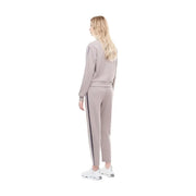 Une femme porte un ensemble de survêtement coordonné en coton mélangé mauve avec des rayures verticales, idéal pour l'automne et l'hiver.
