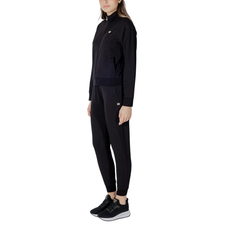 Ea7 Combinaison pantalon noire en coton pour femme, fermeture éclair mandarine, veste zippée en tissu lisse et pantalon de jogging fuselé avec logo discret.
