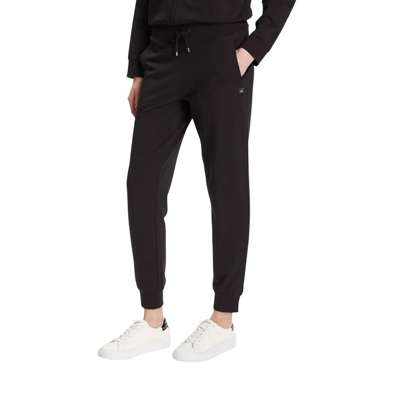 Ea7 Combinaison pantalon noire en coton à col roulé pour femme, avec pantalon de jogging noir extensible et doux, et logo discret visible sur la cuisse.