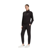 Ea7 Combinaison noire en coton à col roulé pour femme, portée avec un survêtement noir zippé Tommy Hilfiger et des baskets blanches.
