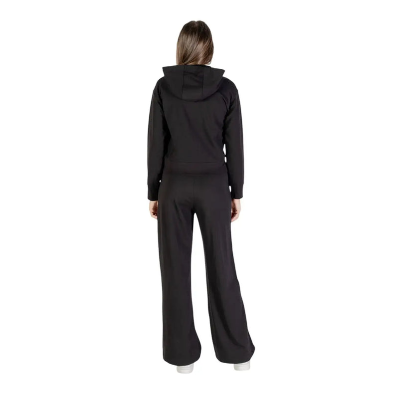 Ea7 Ensemble combinaison pantalon à capuche zippée en coton noir pour femme, comprenant un sweat-shirt et un pantalon à jambes larges (vue de face).