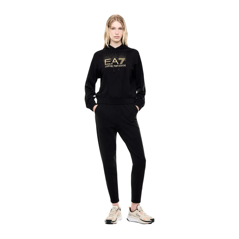 Ea7 Combinaison pantalon en coton noir à capuche pour femme, idéale pour l'automne, comprenant un sweat à capuche noir EA7 Emporio Armani avec logo brodé doré et un pantalon de jogging assorti.