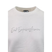 Sweat-shirt blanc EA7 Emporio Armani avec logo strass étincelant sur la poitrine, porté avec une combinaison en coton gris.