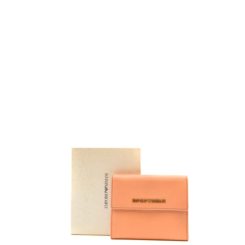 Un portefeuille en cuir couleur pêche avec une plaque logo Emporio Armani dorée, conçu pour les femmes et doté de poches.