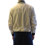 Blouson aviateur beige à col et poignets côtelés noirs en nylon léger, porté avec un blazer à col roulé zippé gris en polyester Fay pour homme