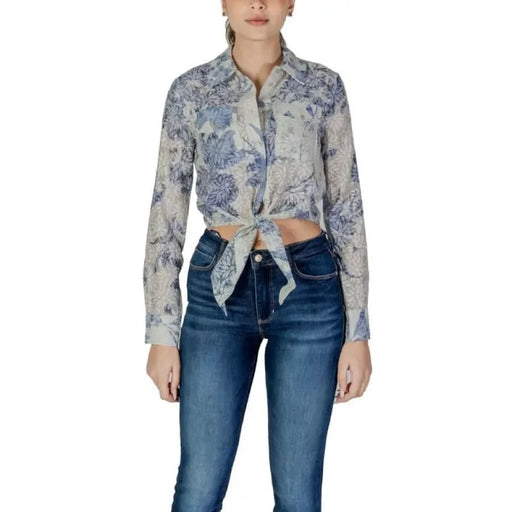 Floral print button-up shirt tied at the waist with blue jeans by Guess Women’s collection