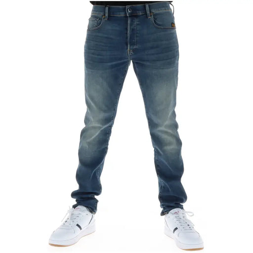 Jean G-Star homme 51001, coupe slim, en denim brut, braguette boutonnée, doublure en coton stretch et étiquette marron.