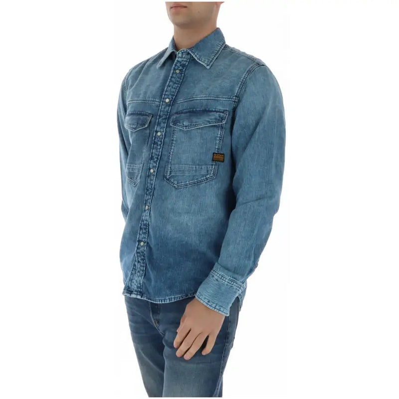Chemise homme G-Star en denim bleu à manches longues, deux poches poitrine et petite étiquette marron sur la poche gauche.
