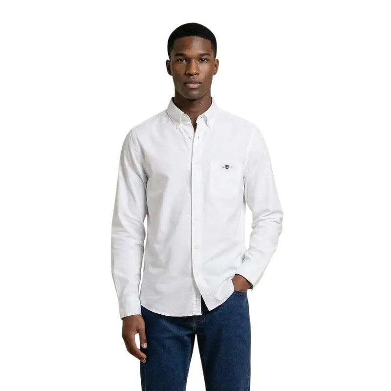 Chemise blanche à manches longues en coton, boutonnée, avec logo brodé discret sur la poche poitrine gauche, de la marque Gant Men Shirt.