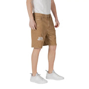 Brown denim cargo shorts with distressed patches and white sneakers