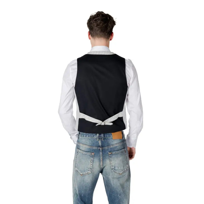Black vest with white shirt and distressed jeans