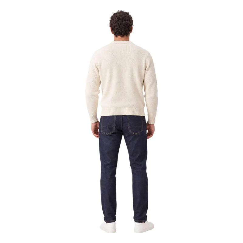 Gianni Lupo Jean carotte pour homme en denim bleu foncé porté par un mannequin avec un pull en maille côtelée crème (vue de face)